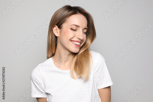 Portrait of young woman with beautiful face on grey background