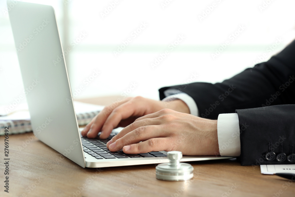 Male notary working with laptop at table, closeup Male notary working with laptop at table, closeup