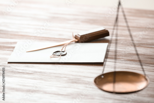 Document with notary seal and letter opener on wooden table