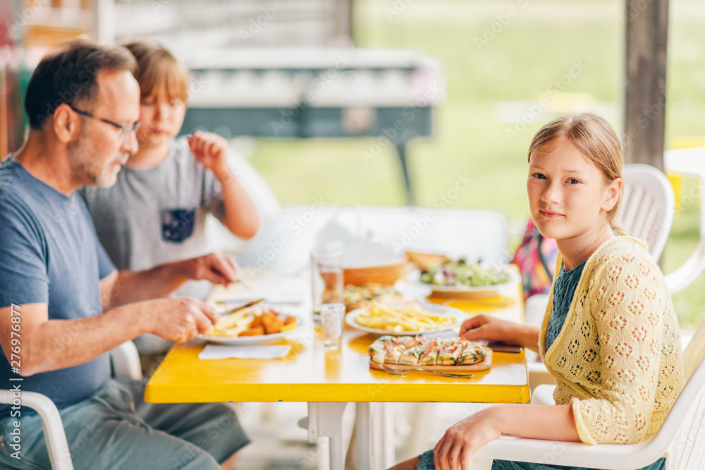 Family having lunch outside on a terrace, background with meal