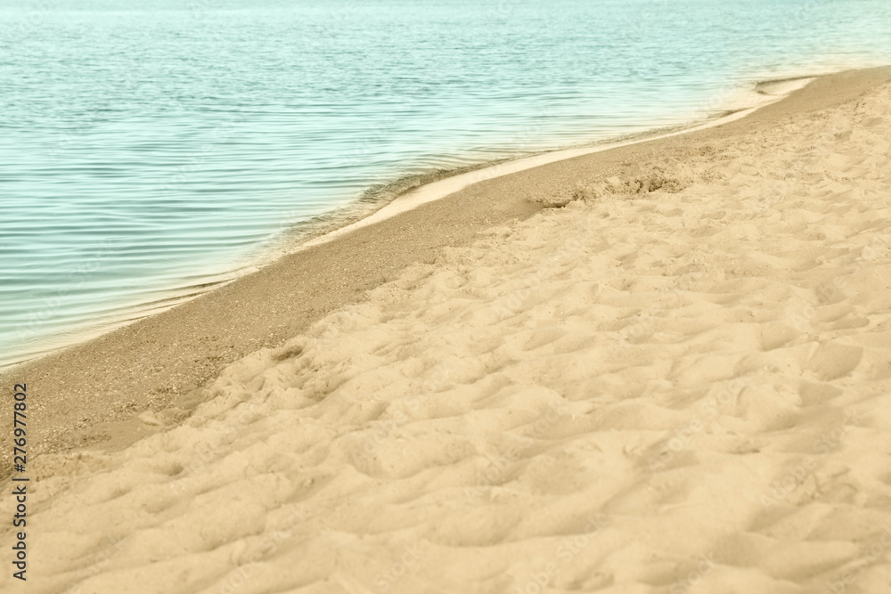 View of sea water and beach sand on sunny summer day View of sea water and beach sand on sunny summer day