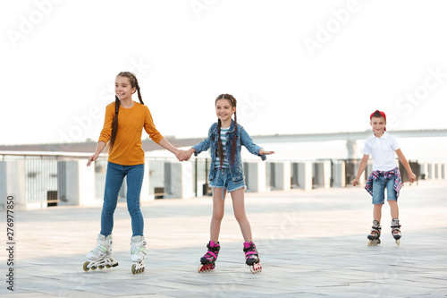 Little children roller skating on city street