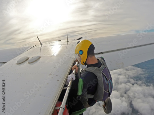 Parachutist hanging on the airplane door