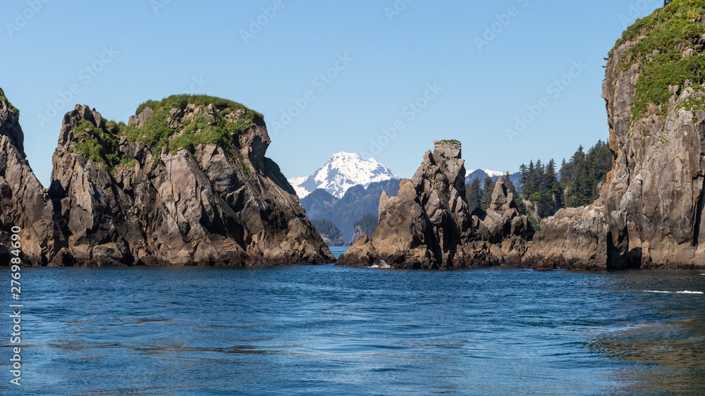 View of snow capped mountin and rock formation from the sea