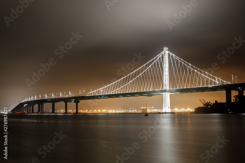 Reflections of fog and water on the Bay Bridge eastern span on a summer night. Yerba Buena Island, San Francisco, California, USA.
