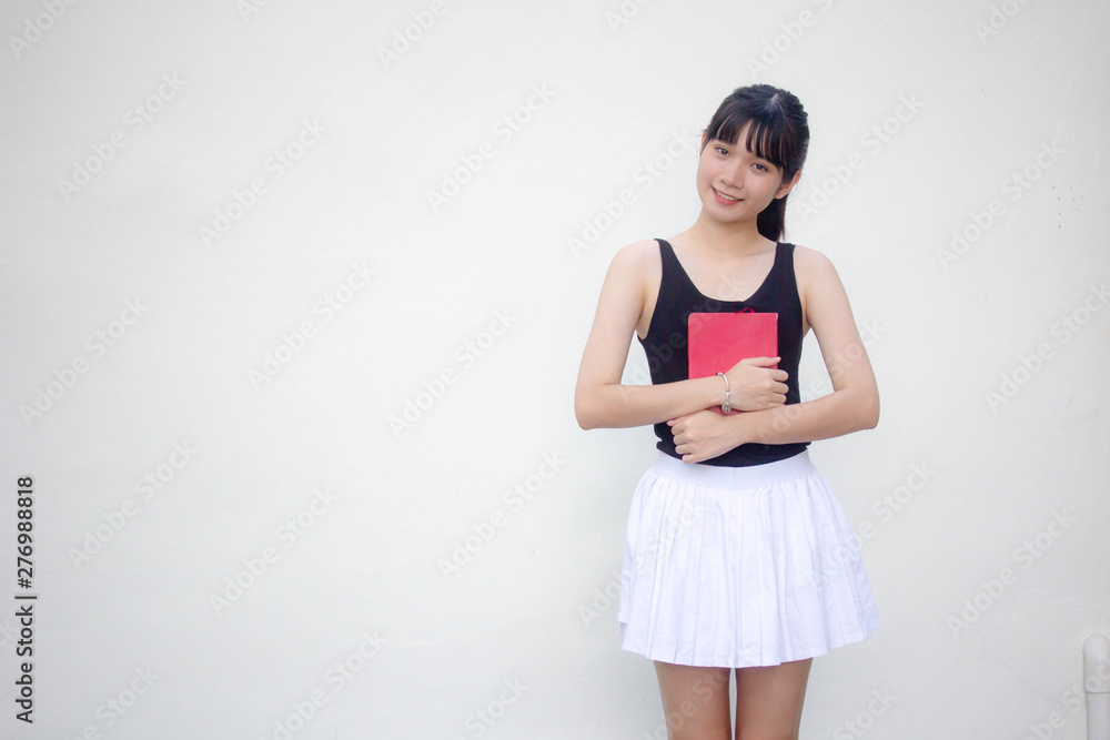 Portrait of thai adult beautiful girl black shirt white skirt and red book Portrait of thai adult beautiful girl black shirt white skirt and red book