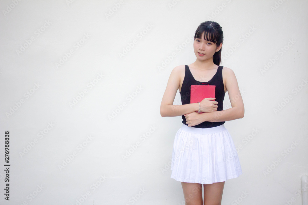 Portrait of thai adult beautiful girl black shirt white skirt and red book Portrait of thai adult beautiful girl black shirt white skirt and red book