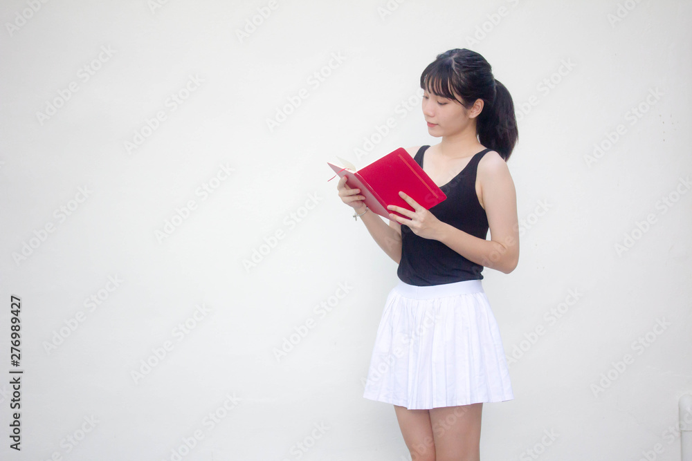 Portrait of thai adult beautiful girl black shirt white skirt reading red book Portrait of thai adult beautiful girl black shirt white skirt reading red book