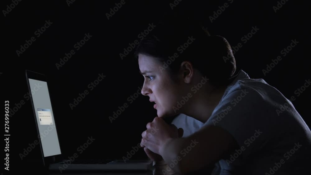 Nervous woman waiting for files downloading or upgrading of software on laptop Nervous woman waiting for files downloading or upgrading of software on laptop