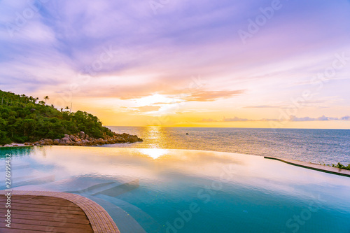 Beautiful outdoor infinity swimming pool in hotel resort with sea ocean view and white cloud blue sky