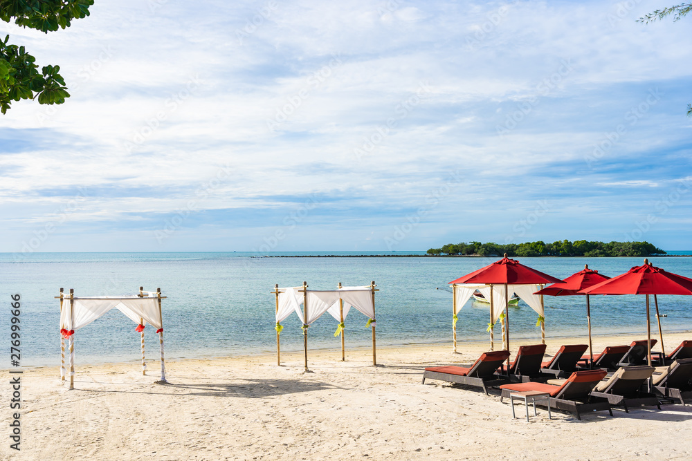 Fototapeta premium Beautiful outdoor tropical beach sea ocean with umbrella chair and lounge deck around there on white cloud blue sky