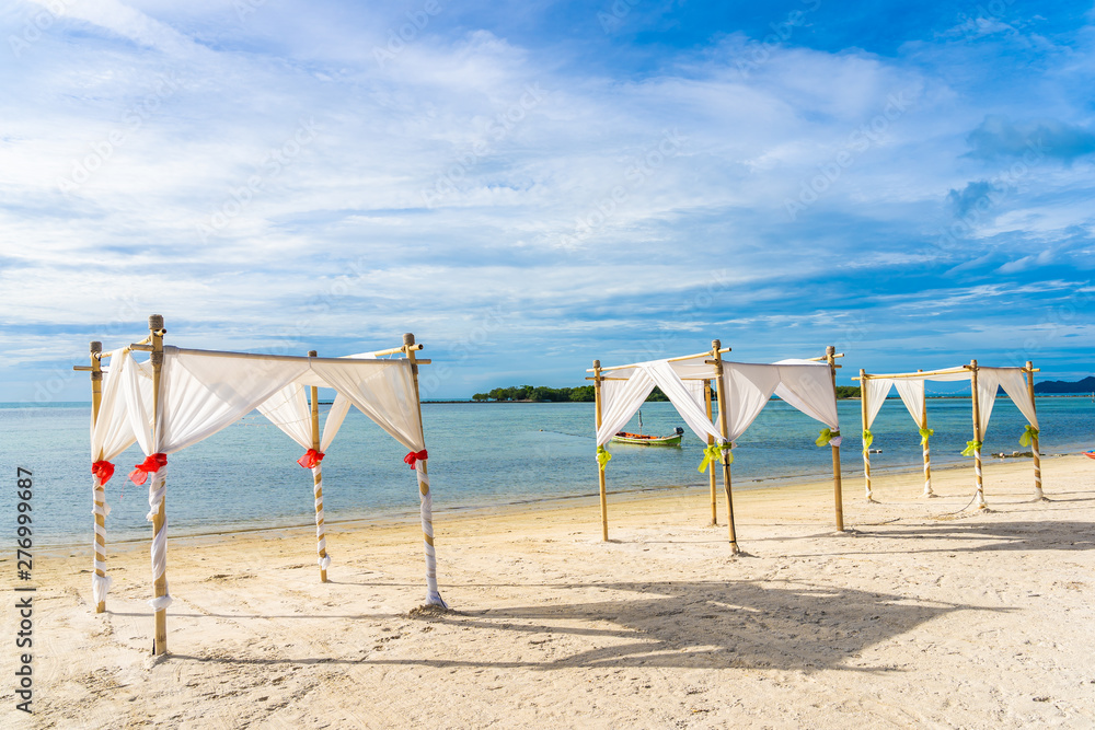 Beautiful outdoor tropical beach sea ocean with umbrella chair and lounge deck around there on white cloud blue sky Beautiful outdoor tropical beach sea ocean with umbrella chair and lounge deck around there on white cloud blue sky