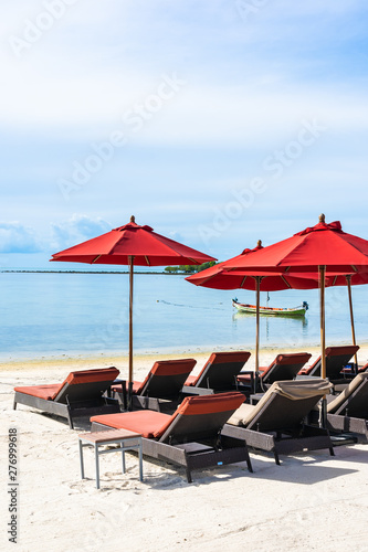 Beautiful outdoor tropical beach sea ocean with umbrella chair and lounge deck around there on white cloud blue sky © siraphol