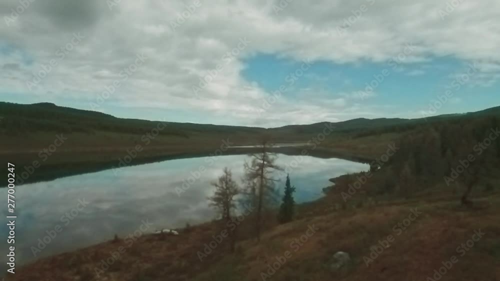 Aerial view of mountain lake with beautiful clouds reflected in a water surfac. coniferous forest on the shore Aerial view of mountain lake with beautiful clouds reflected in a water surfac. coniferous forest on the shore