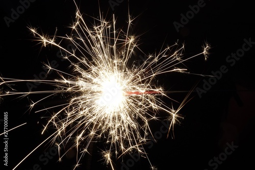 sparkler on black background during 4th of July celebrations.