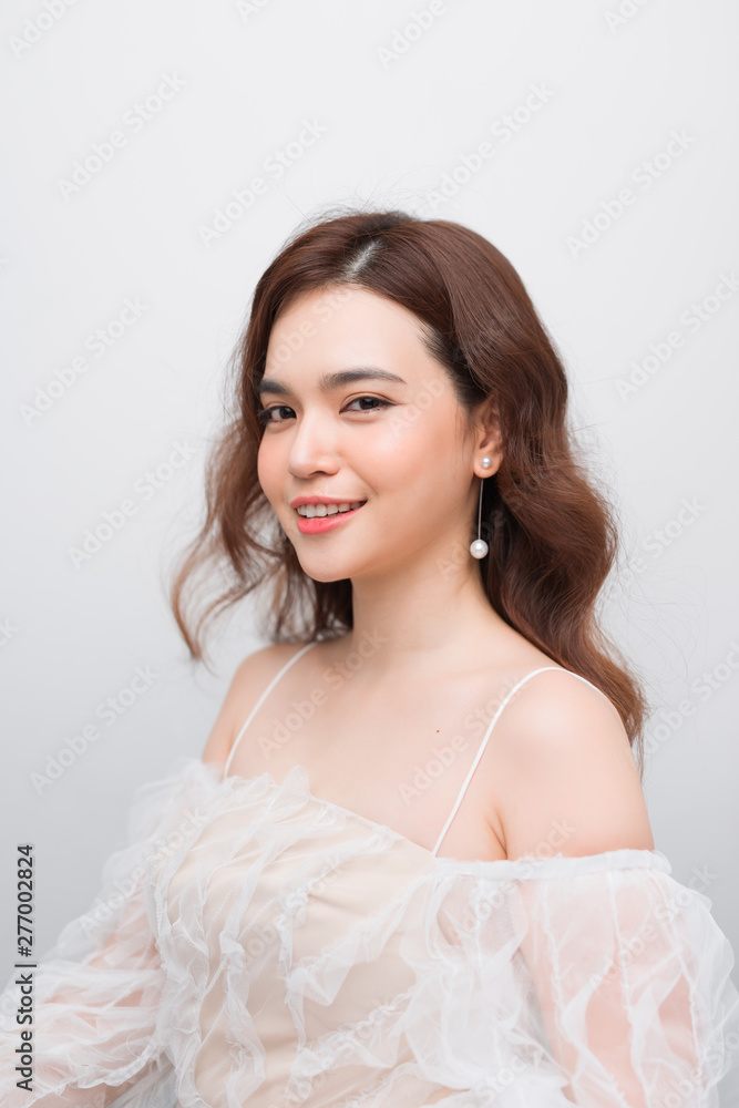 Beautiful smiling young asian woman with clean, fresh, glow, and perfect skin in white dress Beautiful smiling young asian woman with clean, fresh, glow, and perfect skin in white dress