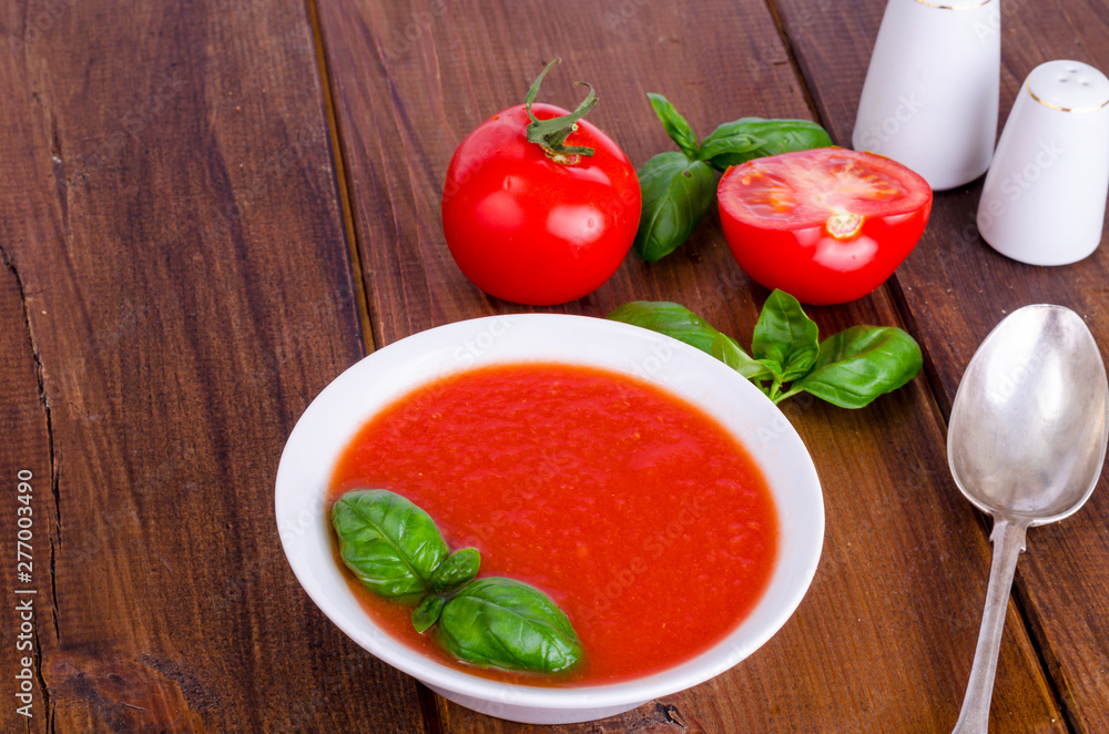 Cold tomato soup on wooden surface. Photo Cold tomato soup on wooden surface. Photo