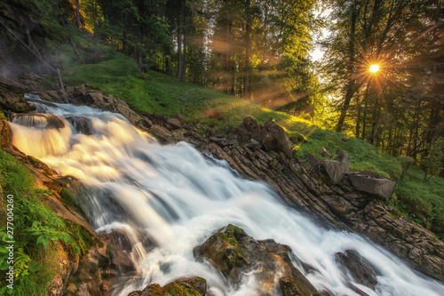 mountain river in the forest with sunbeams