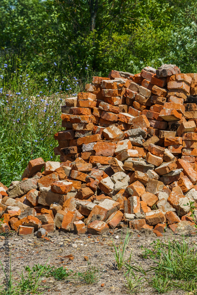 red brick, second-hand lay in a pile on green grass