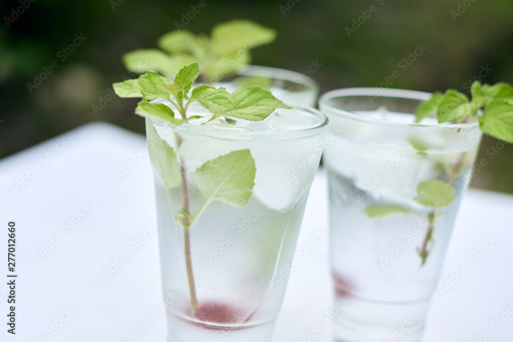 Summer hot fresh drink with mint in glass on white green grey background Summer hot fresh drink with mint in glass on white green grey background