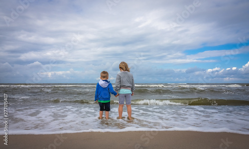 Kids standing in a sea waters