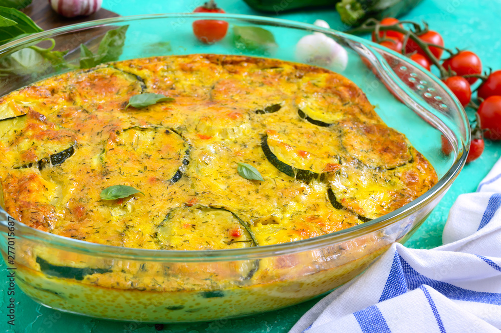Zucchini, cheese, eggs, cream and green casserole in a transparent glass form on a bright background. Tasty healthy dish. Zucchini, cheese, eggs, cream and green casserole in a transparent glass form on a bright background. Tasty healthy dish.