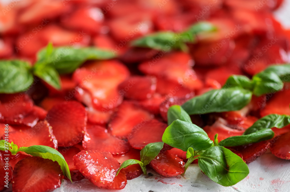 plate of strawberries with sliced ​​basil leaves
