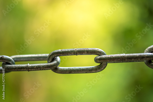 Fragment of a metal chain against the background of brightly green