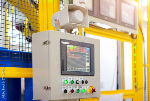 Factory 4.0 concept : View of operation panel and product inspection monitoring display on fence of manufacturing machine.