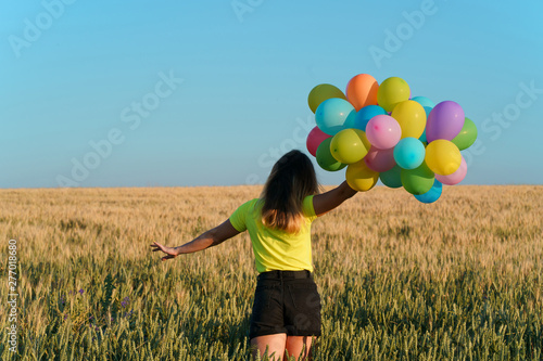 Fototapeta Naklejka Na Ścianę i Meble -  follow your dream, inspiration concept, young woman with colorful balloons in summer field. fun, vacation, bright life
