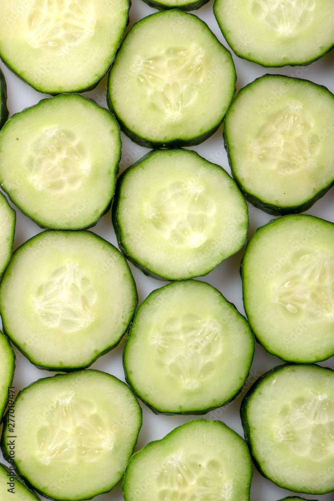 fresh green cucumber, cut with rings on a white background fresh green cucumber, cut with rings on a white background