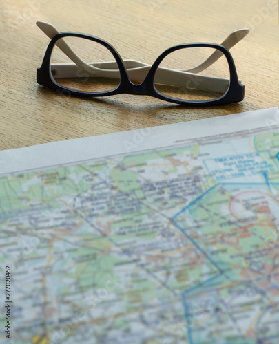 The map of the area is blurred and near glasses for poor vision with lenses