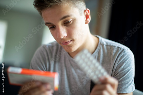 Foto Teenage Boy With Mental Health Problems Taking Medication At Home