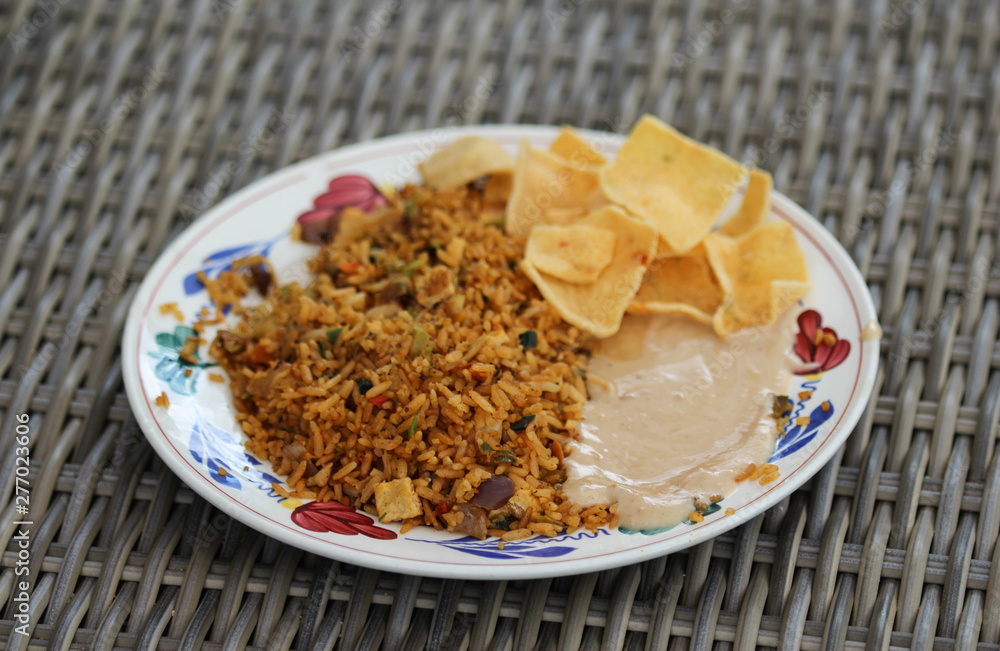 Plate with Indonesian nasi goreng with peanut sauce and Krupuk Plate with Indonesian nasi goreng with peanut sauce and Krupuk