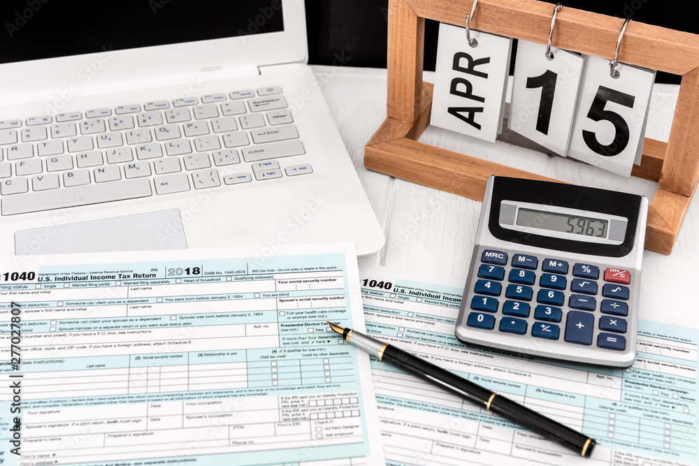 Obraz premium Tax form on white background. With notebook, calculator, pen