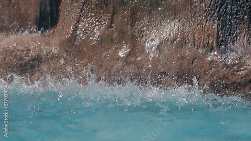 Wallpaper Mural water drops fall on pool surface spraying against brown decorative rocks at resort hotel closeup slow motion Torontodigital.ca
