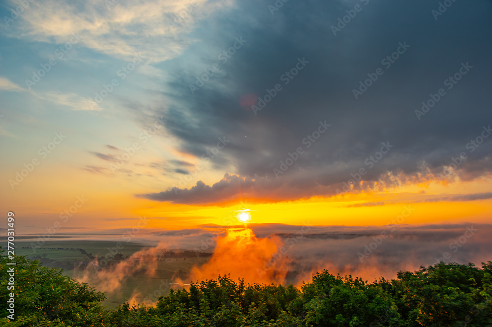 Obraz premium Dawn on a misty morning on a mountain above the river