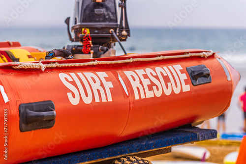Konstfotografi A red life saving surf rescue inflatable boat with a black outboard motor on the