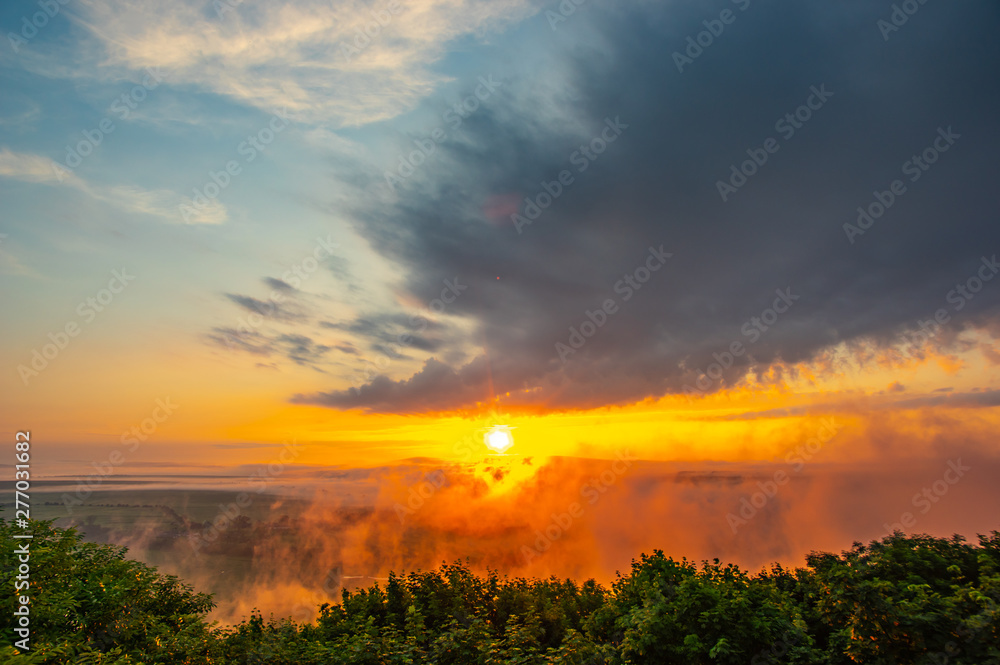 Dawn on a misty morning on a mountain above the river