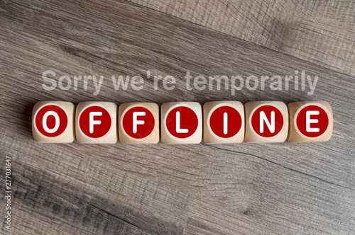 Cubes and dice on wooden background with message Sorry were temporarily offline