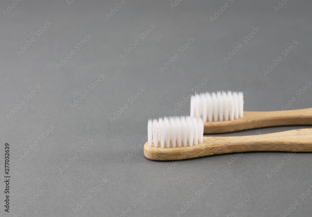 Close up wooden toothbrush on grey background, selective focus Close up wooden toothbrush on grey background, selective focus