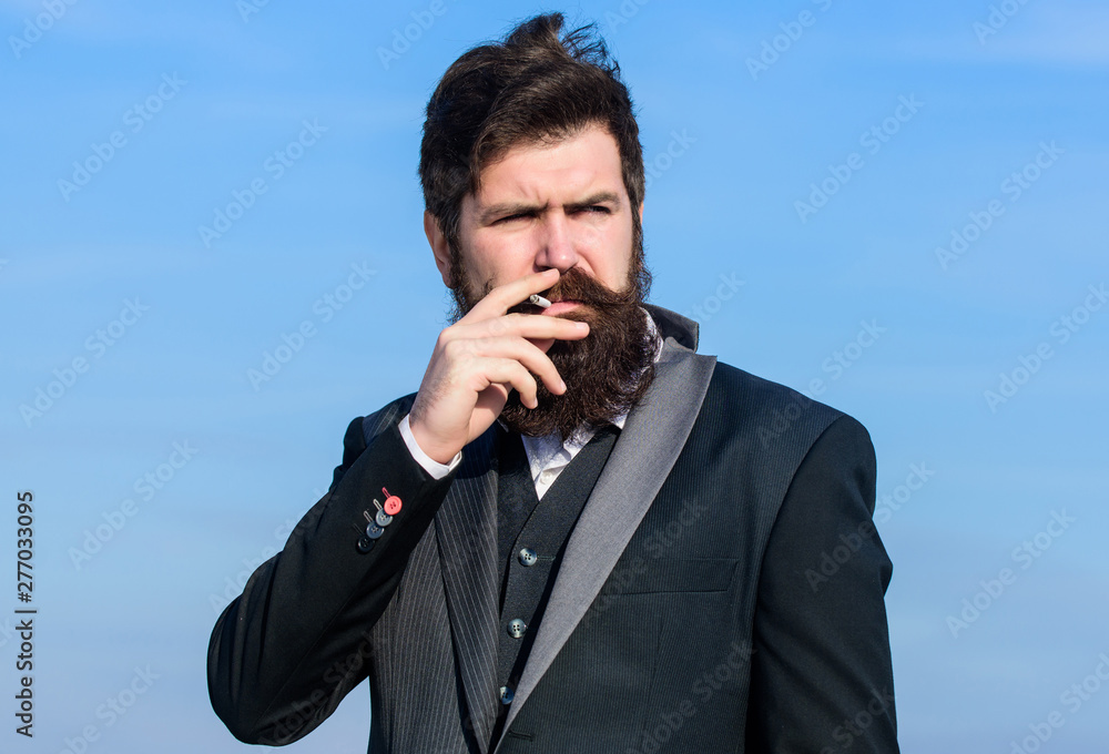Truth about smoking pleasure and nicotine addiction. Guy with cigarette enjoy nicotine influence. Man with beard and mustache hold cigarette. Bearded hipster smoking cigarette blue sky background Truth about smoking pleasure and nicotine addiction. Guy with cigarette enjoy nicotine influence. Man with beard and mustache hold cigarette. Bearded hipster smoking cigarette blue sky background