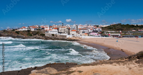 Fototapeta Naklejka Na Ścianę i Meble -  Praia das Maçãs, Portugal on a sunny summer day - a beautiful view of the beach & village, large waves and a blue sky.