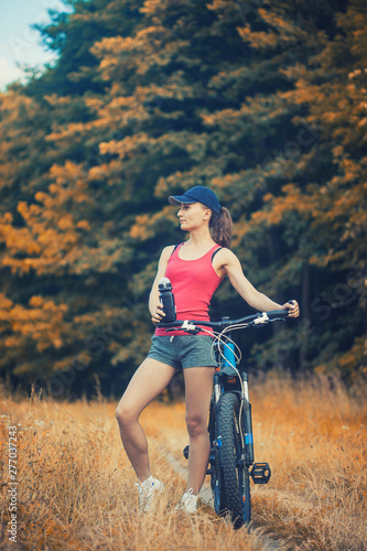 cute woman cyclist cycling mountain bike in the summer park