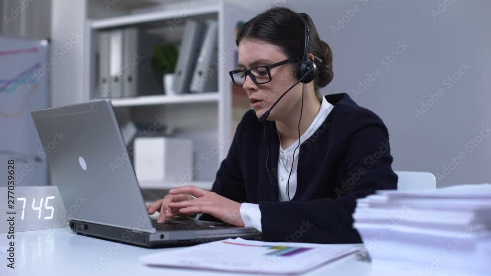 Overloaded female taking off headset and lying on laptop, exhausted after work