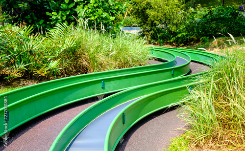 colorful long slide view in public forest playground