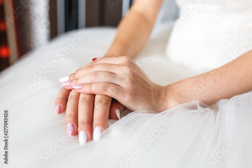 women's hands folded on their knees in anticipation of the wedding and the groom