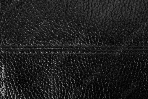Black leather background texture with a seam in the middle