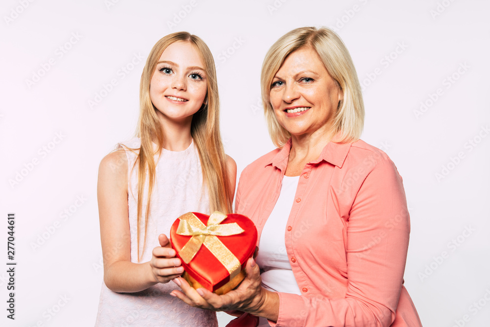 Surprise! I love my grandma. Family holidays and celebrations. Close up photo of happy grandmother and granddaughter in good and fun mood isolated together on white background. Surprise! I love my grandma. Family holidays and celebrations. Close up photo of happy grandmother and granddaughter in good and fun mood isolated together on white background.