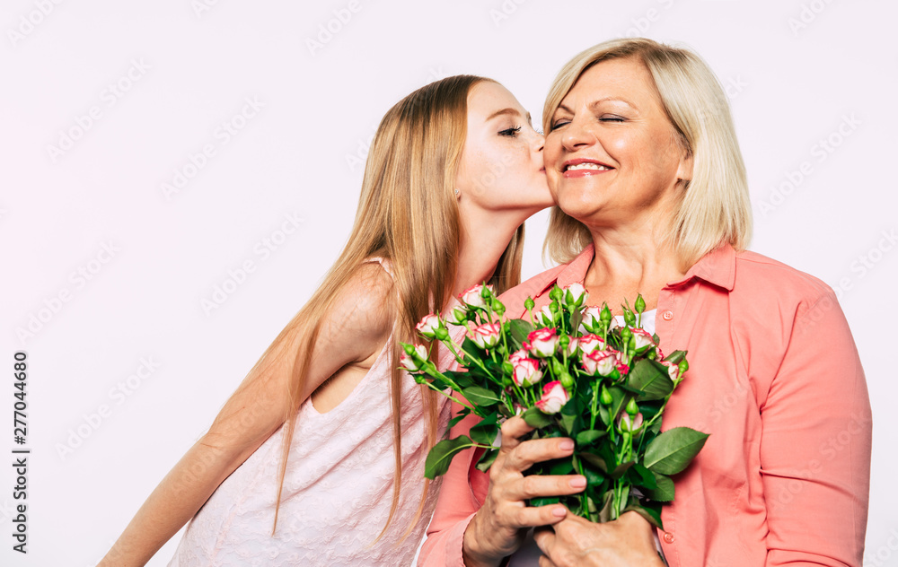Surprise! I love my grandma. Family holidays and celebrations. Close up photo of happy grandmother and granddaughter in good and fun mood isolated together on white background. Surprise! I love my grandma. Family holidays and celebrations. Close up photo of happy grandmother and granddaughter in good and fun mood isolated together on white background.